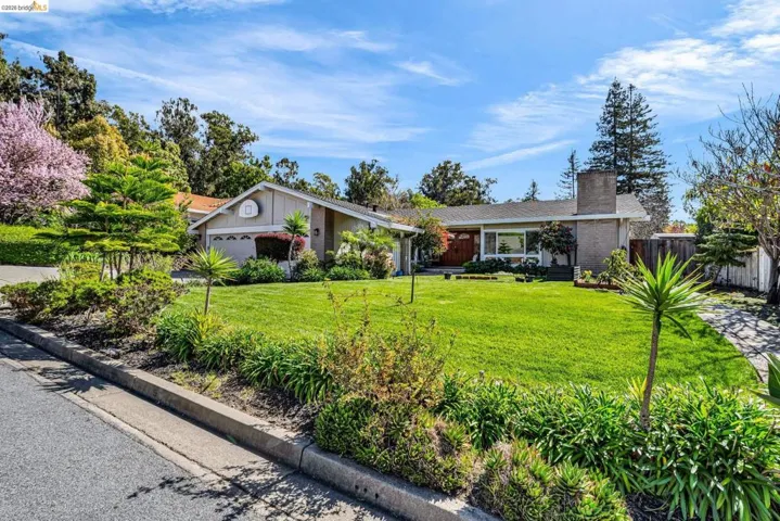 View of front of home with a chimney, board and batten siding, brick siding, and an attached garage