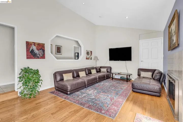 Living room with lofted ceiling and light wood-style floors