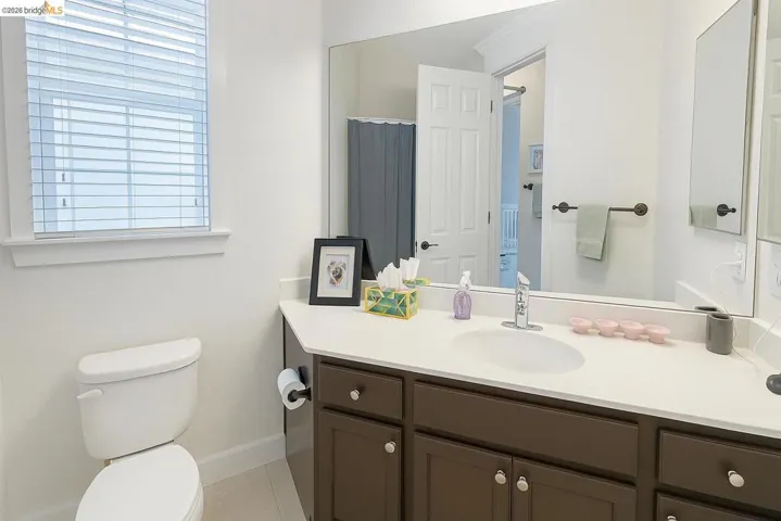 Full bath featuring vanity and light tile patterned floors