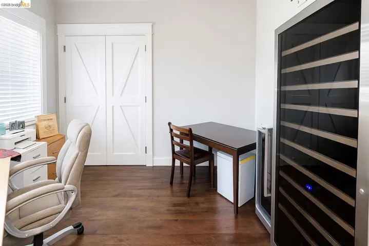 Office with wine cooler and dark wood-style floors