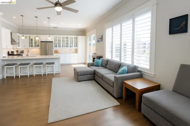 Living area with ceiling fan, crown molding, dark wood-type flooring, and recessed lighting