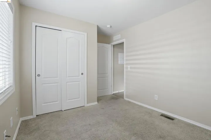 Unfurnished bedroom featuring light colored carpet and a closet