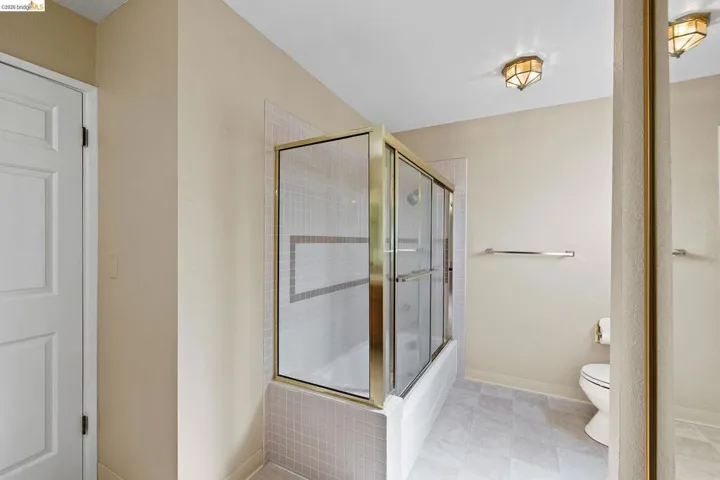 Full bath with toilet and bath / shower combo with glass door