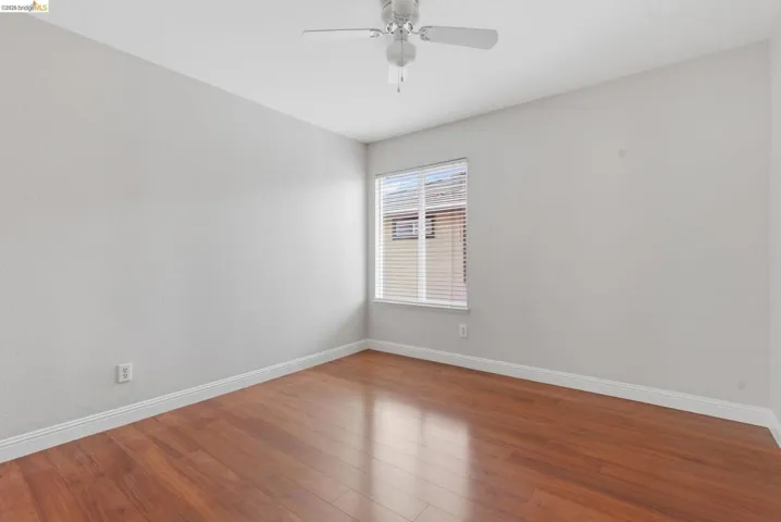 Empty room with wood finished floors and ceiling fan