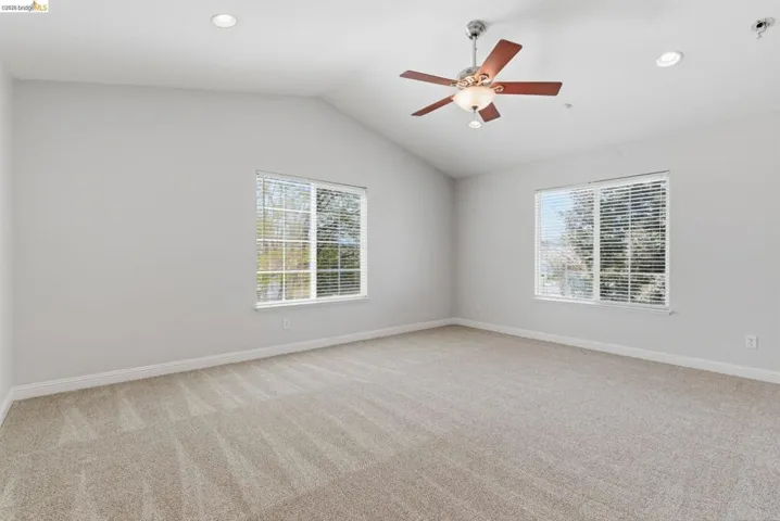 Unfurnished room with light carpet, healthy amount of natural light, ceiling fan, and recessed lighting