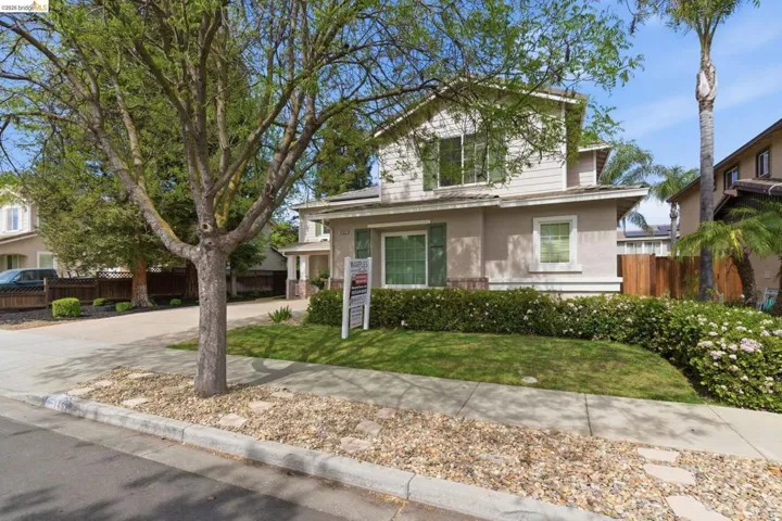 Traditional home featuring stucco siding and concrete driveway