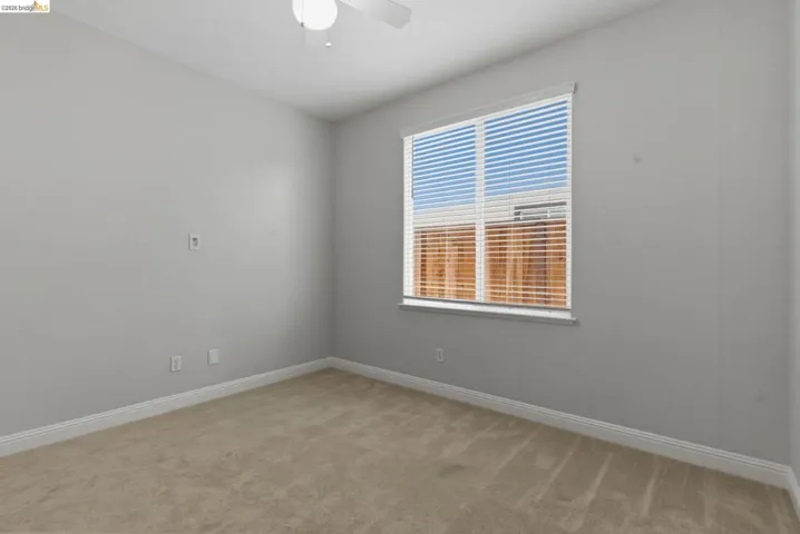 Spare room with light colored carpet and a ceiling fan