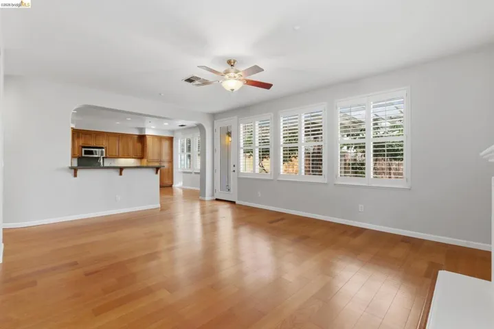 Unfurnished living room featuring arched walkways, light wood-style floors, recessed lighting, and ceiling fan