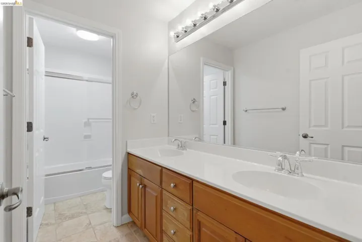 Full bath with double vanity and enclosed tub / shower combo