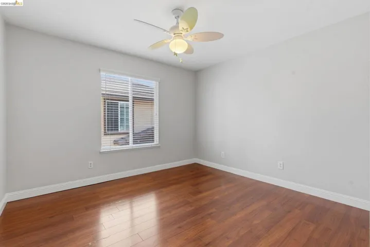 Spare room featuring dark wood finished floors and a ceiling fan
