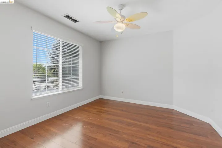 Spare room featuring dark wood-style flooring and a ceiling fan