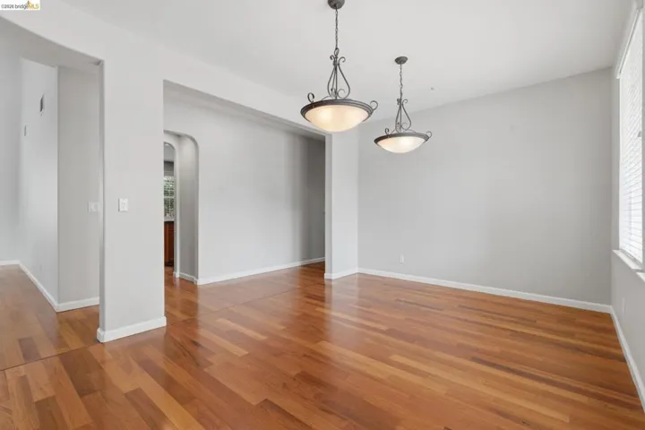 Empty room featuring arched walkways and dark wood-style floors