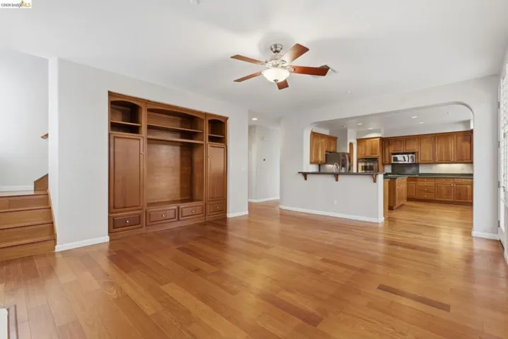 Unfurnished living room with arched walkways, ceiling fan, recessed lighting, and light wood-style flooring