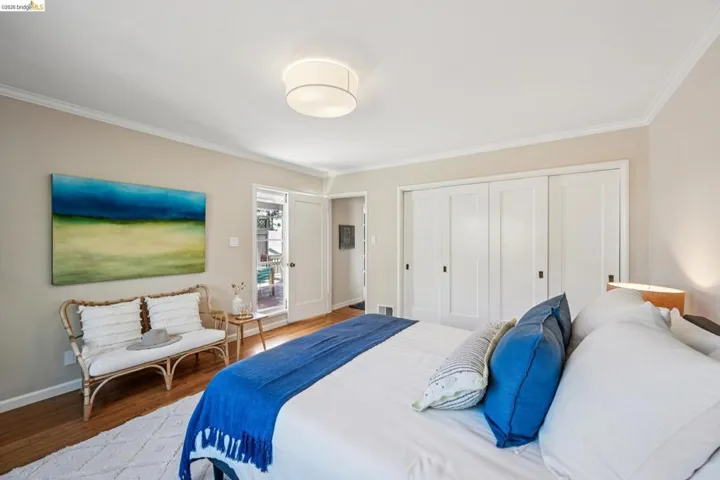 Bedroom featuring a closet, wood finished floors, and ornamental molding
