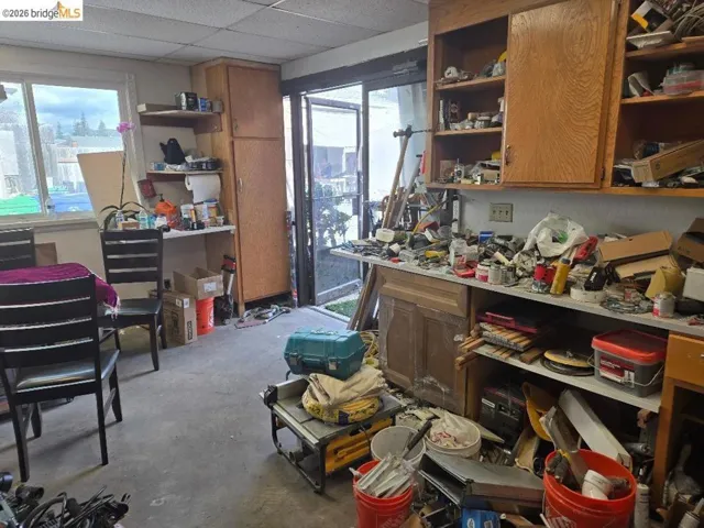 Miscellaneous room featuring unfinished concrete floors and a paneled ceiling