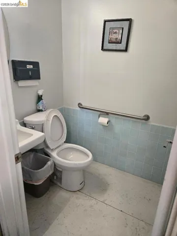 Half bath with tile walls and wainscoting