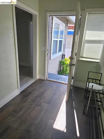 Doorway to outside with hardwood / wood-style flooring and baseboards