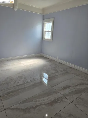 Unfurnished room featuring baseboards and light marble finish floors
