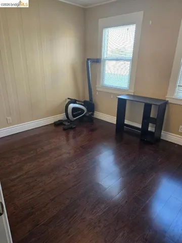 Spare room featuring dark wood-style floors and wooden walls