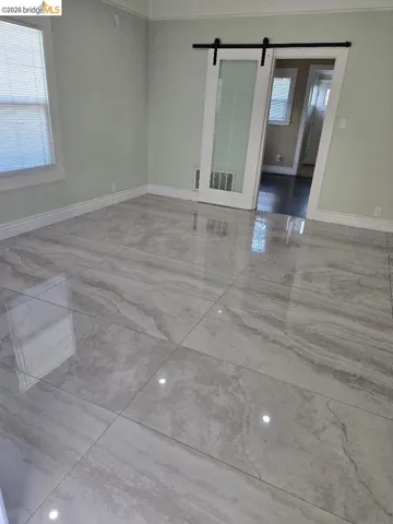 Unfurnished room featuring baseboards and a barn door
