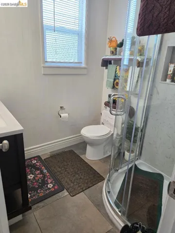 Full bath with vanity, a stall shower, and healthy amount of natural light