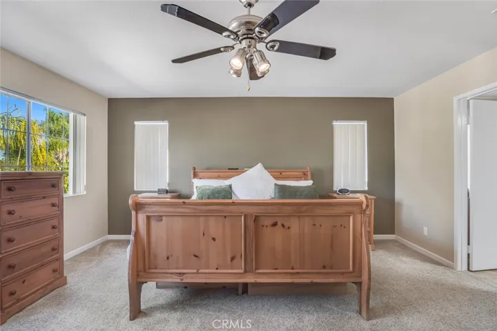 The primary suite feels like a place to truly settle in. Large windows bring in natural light, giving the room a soft, relaxed feel throughout the day.