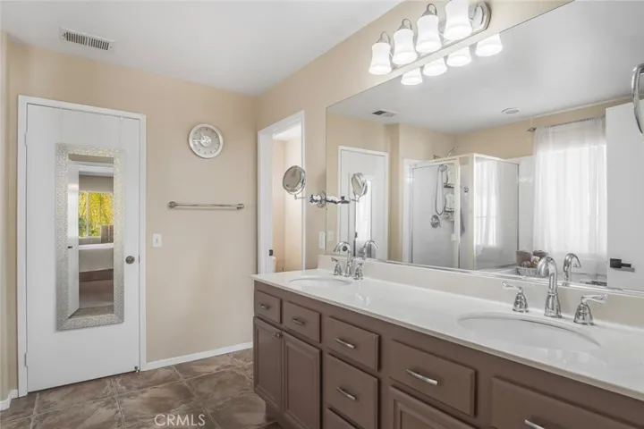 The ensuite bath feels like a private spa, with dual sinks, ample drawers and cabinets, extra large mirror, upgraded tile flooring and elevated lighting. The walk-in closet is designed for comfort and function.