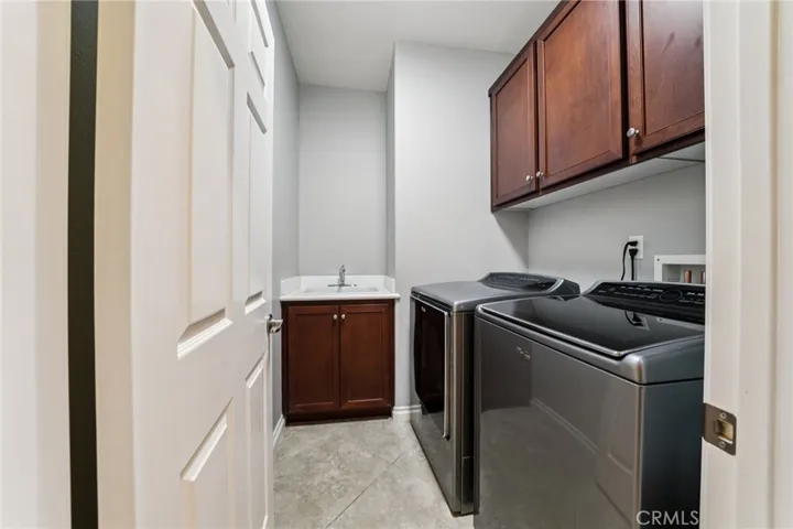 Spacious downstairs laundry room featuring a utility sink