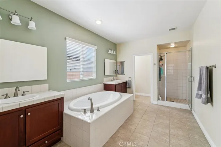 Well-appointed primary bathroom with dual sinks and relaxing soaking tub