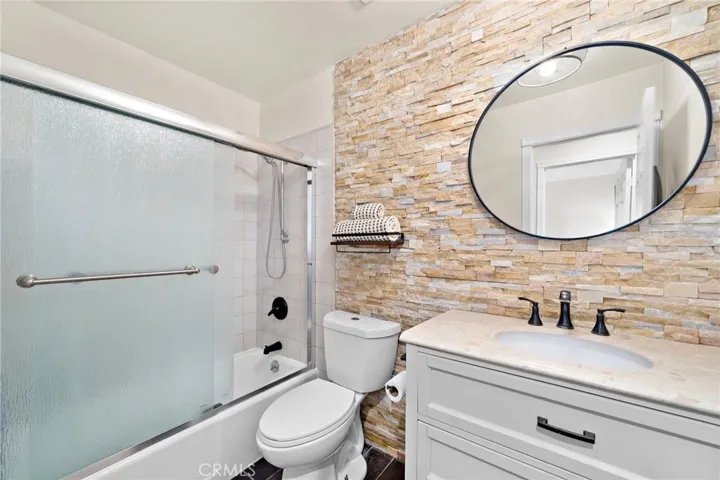 Hall bath with custom designer floor to ceiling stone