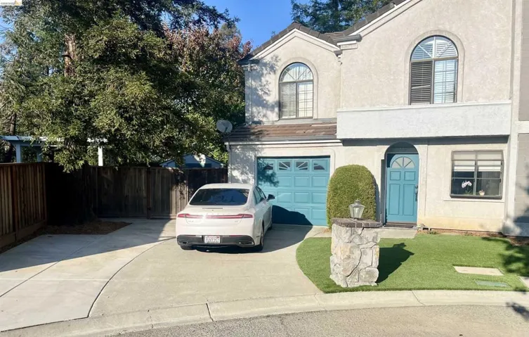 View of front of property featuring stucco siding, concrete driveway, and a garage