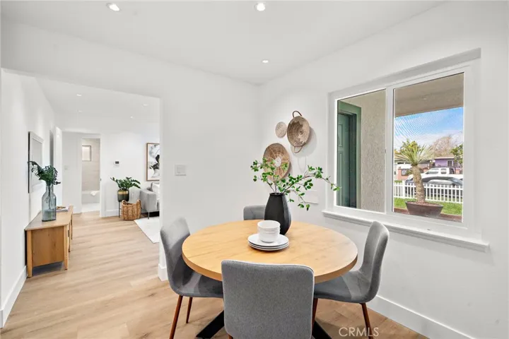 The light and bright living room flows seamlessly into the completely redesigned kitchen boasting quartz countertops, custom self-closing cabinetry, stainless steel appliances, a farmhouse sink, and an eat-in dining area.