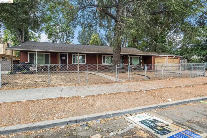Ranch-style house with a fenced front yard, an attached garage, roof with shingles, and a gate