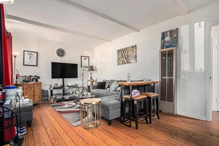 Living area featuring beamed ceiling and light wood finished floors