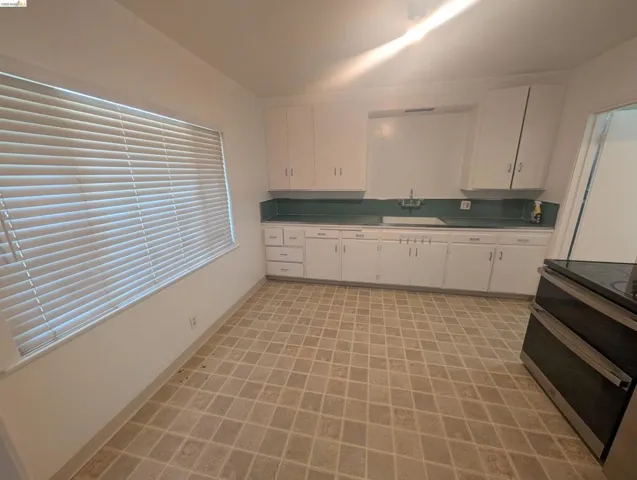 Kitchen featuring white cabinetry and double oven range