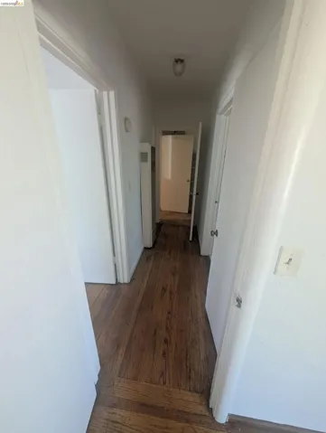 Hallway featuring dark wood-style floors and a heating unit
