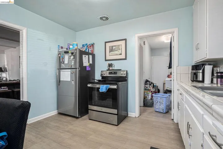 Kitchen featuring white cabinetry and stainless steel appliances