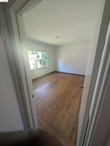 Unfurnished room featuring dark wood finished floors and baseboards