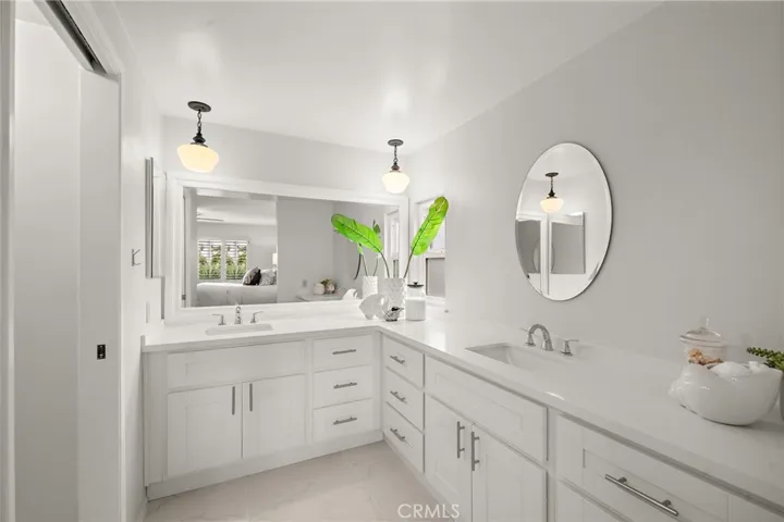 Both the primary and hall bathrooms have been beautifully remodeled with self-closing vanity cabinetry, quartz countertops, dual sinks, new fixtures, and designer tile surrounds;