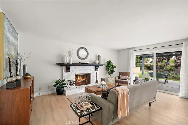 plus both a breakfast bar and charming eat-in breakfast nook that is open to the spacious family room with custom fireplace, full entertainer’s wet bar, and sliding glass doors leading to an unbelievable park-like wrap-around backyard