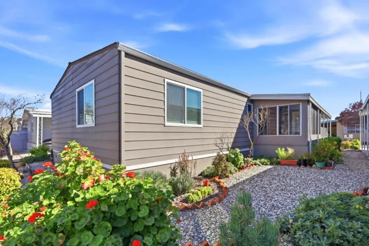 Garden area behind home with view of sunroom.