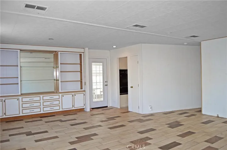 Through the security screen and entry door with built-in blinds, you'll find custom tile flooring throughout this spacious living and dining room with a built-in hutch to display your treasures and easy access to the kitchen off to your right