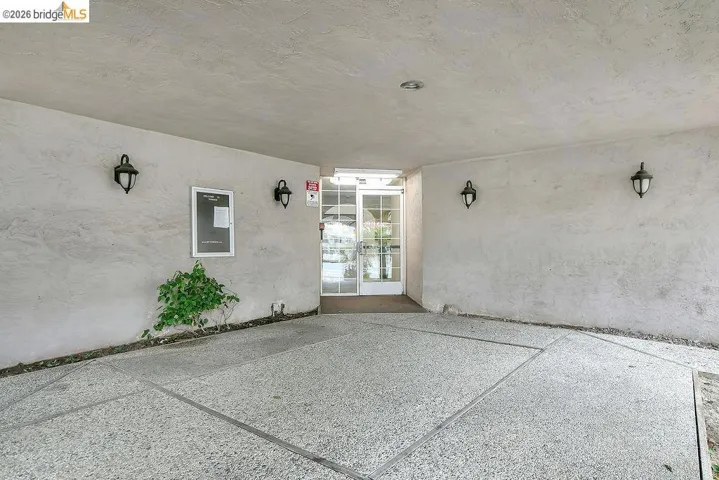 View of exterior entry featuring stucco siding and a patio