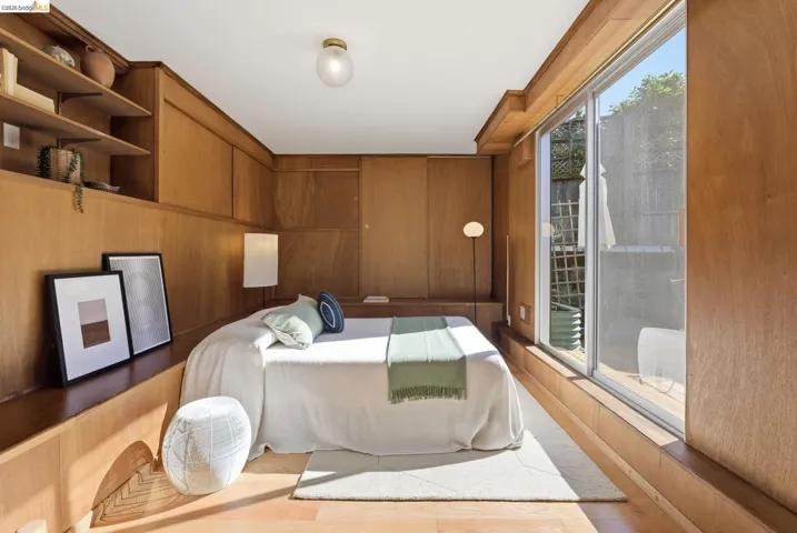 Bedroom featuring wood finished floors and wooden walls