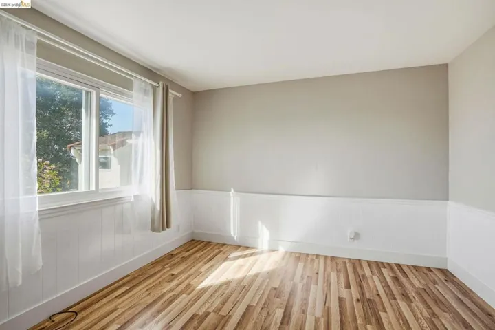 Spare room with light wood-style flooring and wainscoting