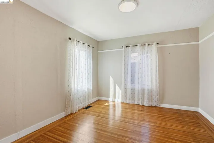 Spare room featuring wood finished floors and baseboards