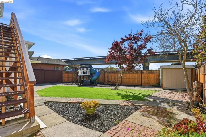 Fenced backyard with stairway and a shed