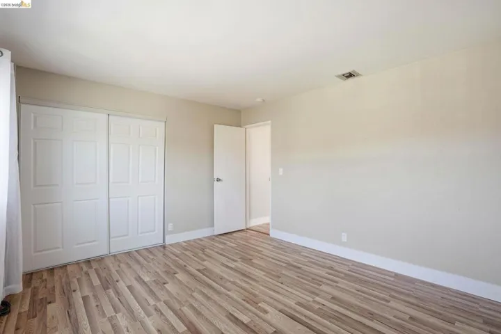 Unfurnished bedroom featuring light wood finished floors and a closet