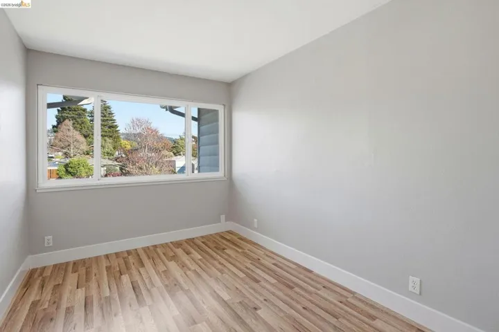 Unfurnished room with light wood finished floors and baseboards