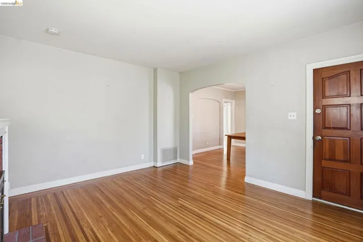 Spare room with arched walkways and wood finished floors